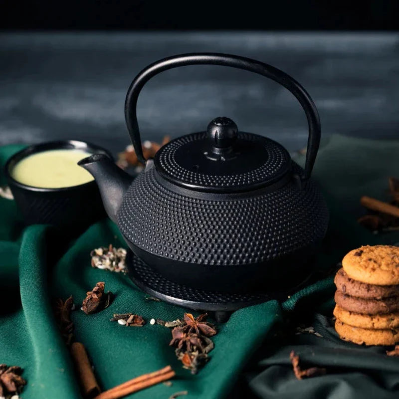Théière en fonte posée sur un tissu vert