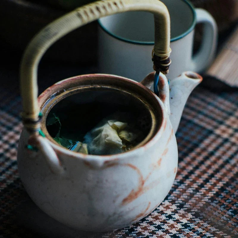 Théière en grès posée sur un tissue à carreaux