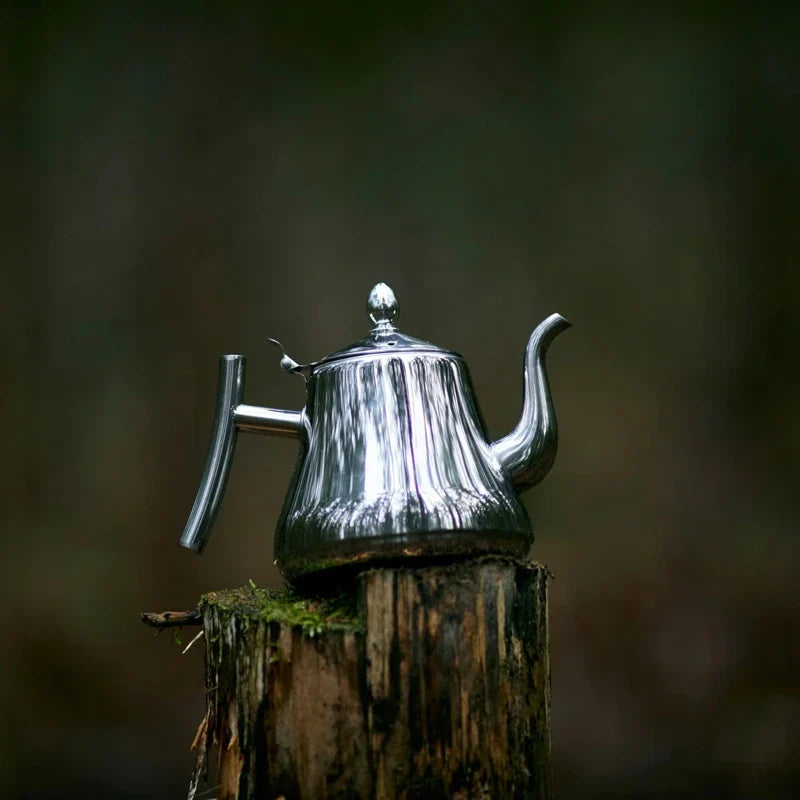 Théière en Inox posée sur une souche de bois