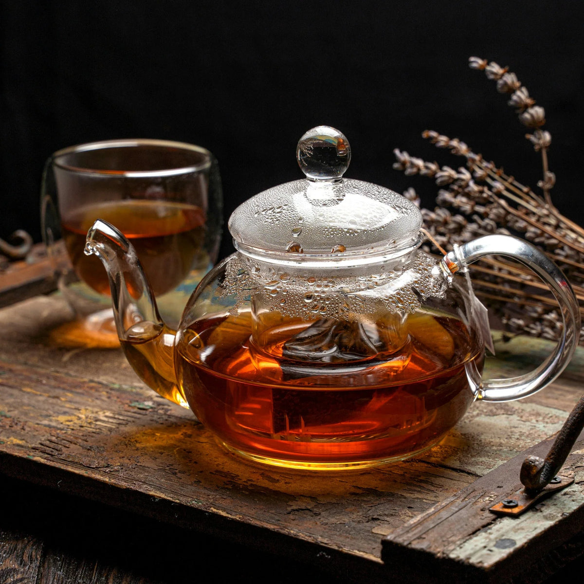 théière en verre sur un plateau en bois 