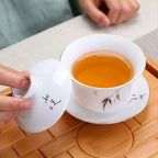 Gaiwan en Porcelaine à Motifs Peint avec du thé dans le gaiwan 