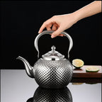 Grande Théière Argentée avec Infuseur 1,2 L — 2 L avec une main qui la tien 