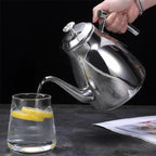 Grande Théière en Inox Argentée versement du thé dans une tasse 