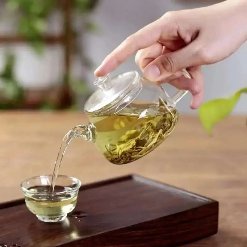 Petite Théière en Verre Borosilicate versant du thé dans une tasse 