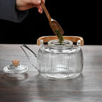 Théière 1L en Verre Borosilicate mettant des feuilles de thé dans la théière 