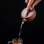 Théière Ancienne en Argile — 130 ml versant du thé dans une tasse 