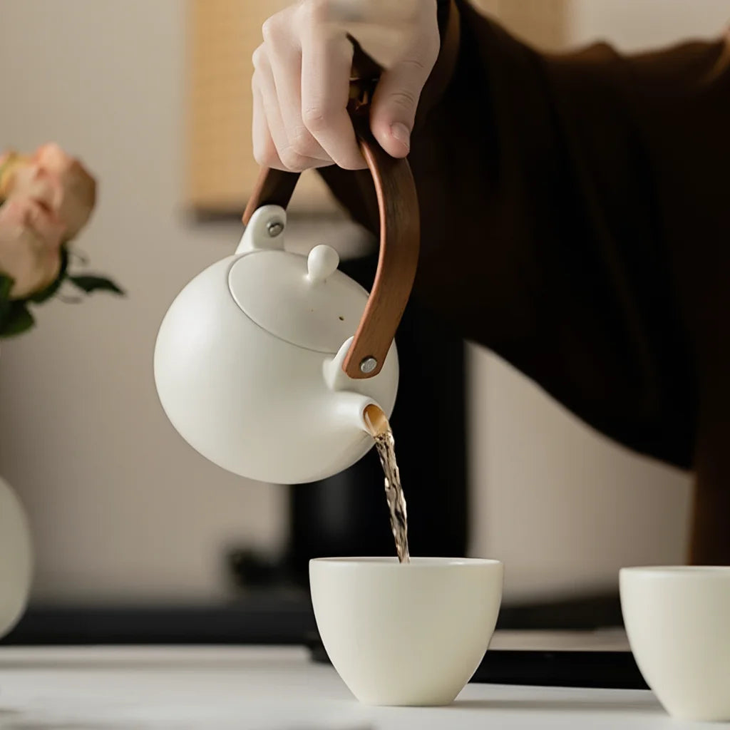 Théière Blanche Japonaise en Porcelaine versant du thé dans une tasse 