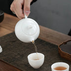 Théière Blanche chinoise en céramique verant du thé 