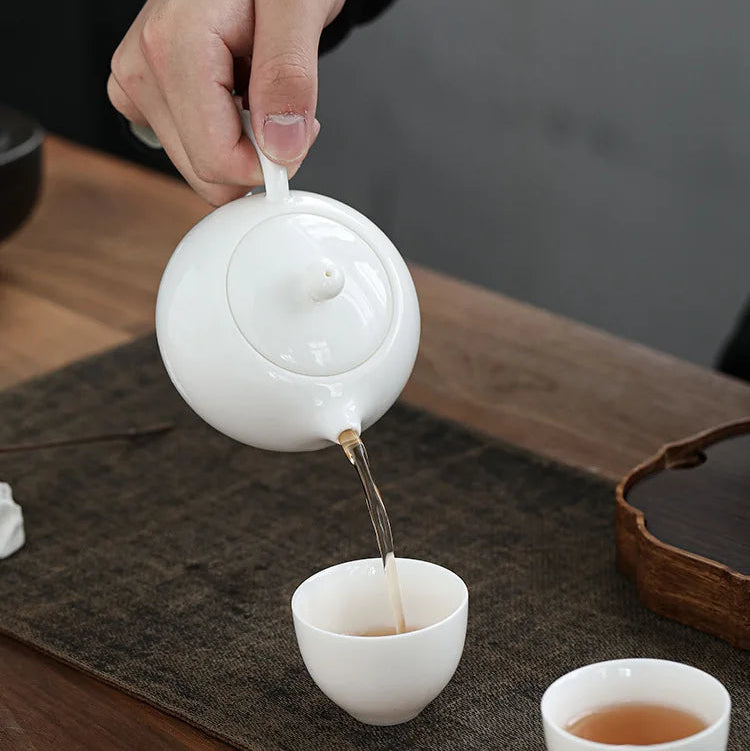 Théière Blanche chinoise en céramique verant du thé 