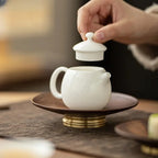 Théière Blanche en Céramique main qui retire le couvercle 