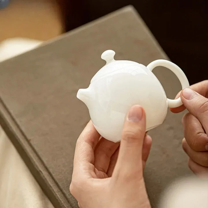 Théière Blanche en Céramique tenu par des mains 