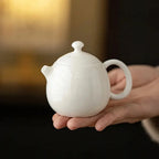 Théière Blanche en Céramique dans une main 