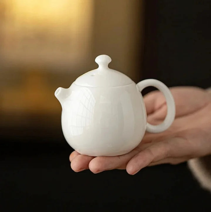 Théière Blanche en Céramique dans une main 