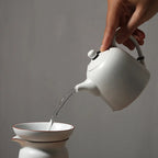 Théière Blanche en Porcelaine versant du thé 