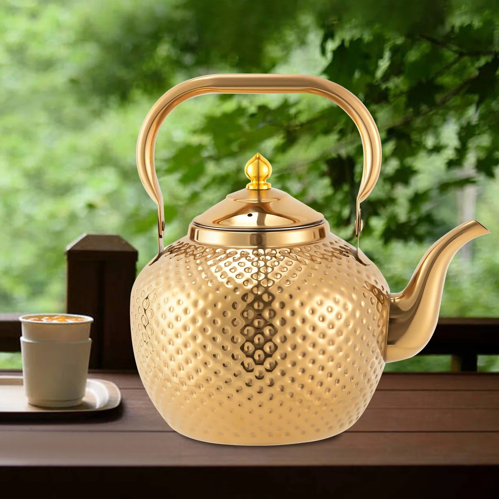 Théière Inox Dorée Martelé sur une table en bois 
