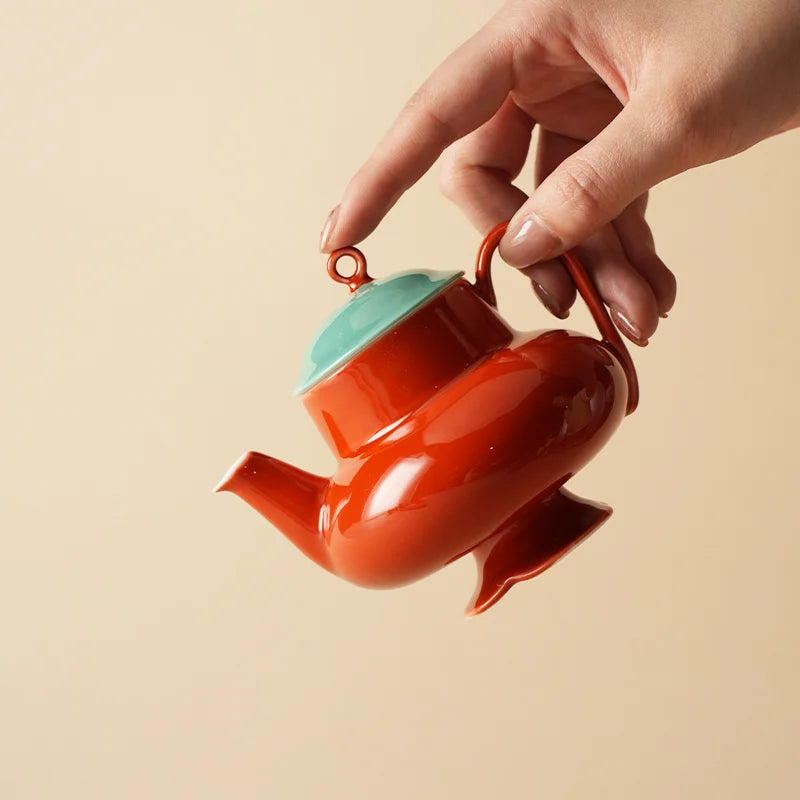 Théière Originale en Céramique Rouge tenu par une main 