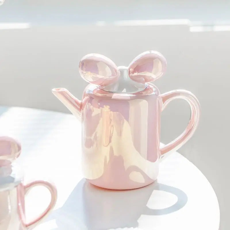 Théière Originale en Porcelaine Rose sur une table blanche 