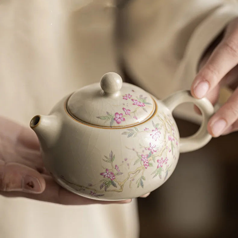Théière Porcelaine Artisanale Fleurie dans une main 