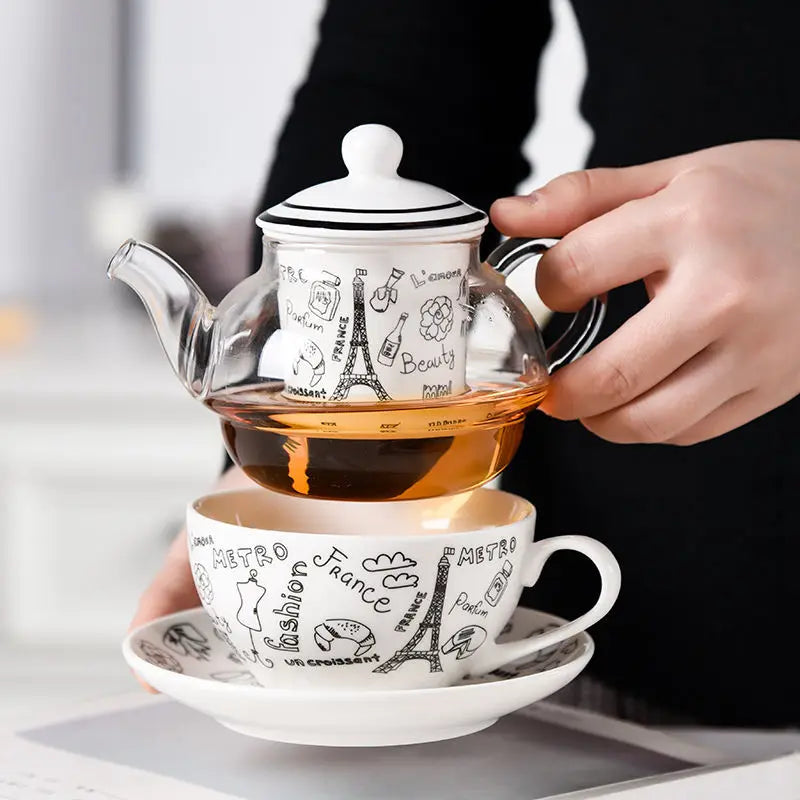 Théière Solitaire en Verre Paris tenu dans une main 