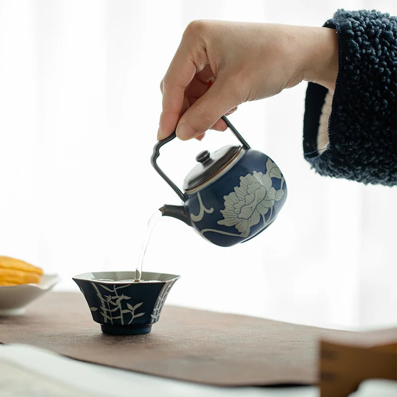 Théière avec Filtre en Porcelaine Florale versant du thé dans une tasse