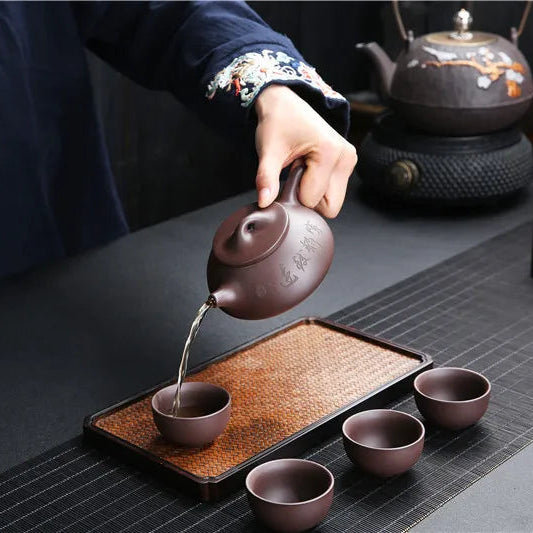 Théière avec Filtre en Terre Cuite Brune verant du thé dans une tasse 