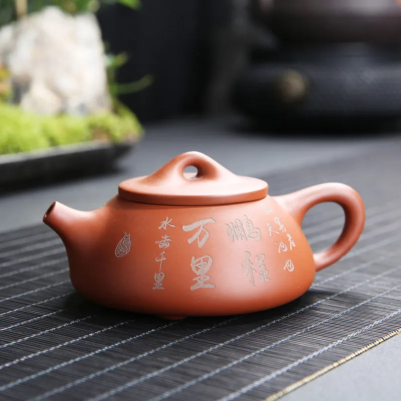 Théière avec Filtre en Terre Cuite Orange sur une surface en maille 

