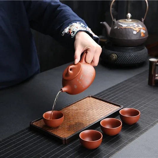 Théière avec Filtre en Terre Cuite Orange versant du thé dans une tasse 