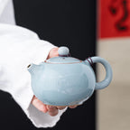 Théière en Céramique Bleu tenu par une main 