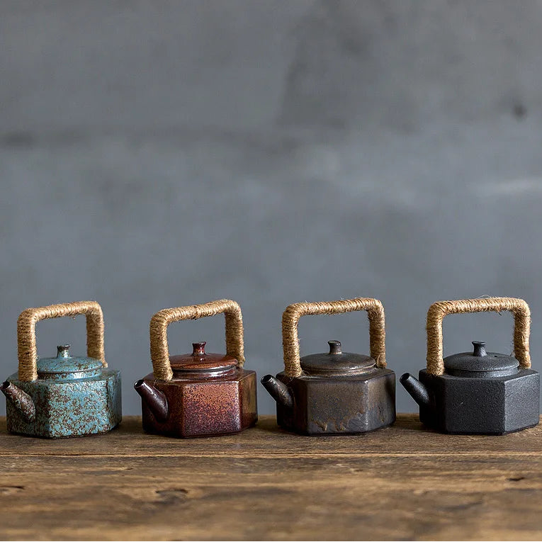 Théière en Grès rouge, bleu, ancien, noir Artisanal posée sur une table 