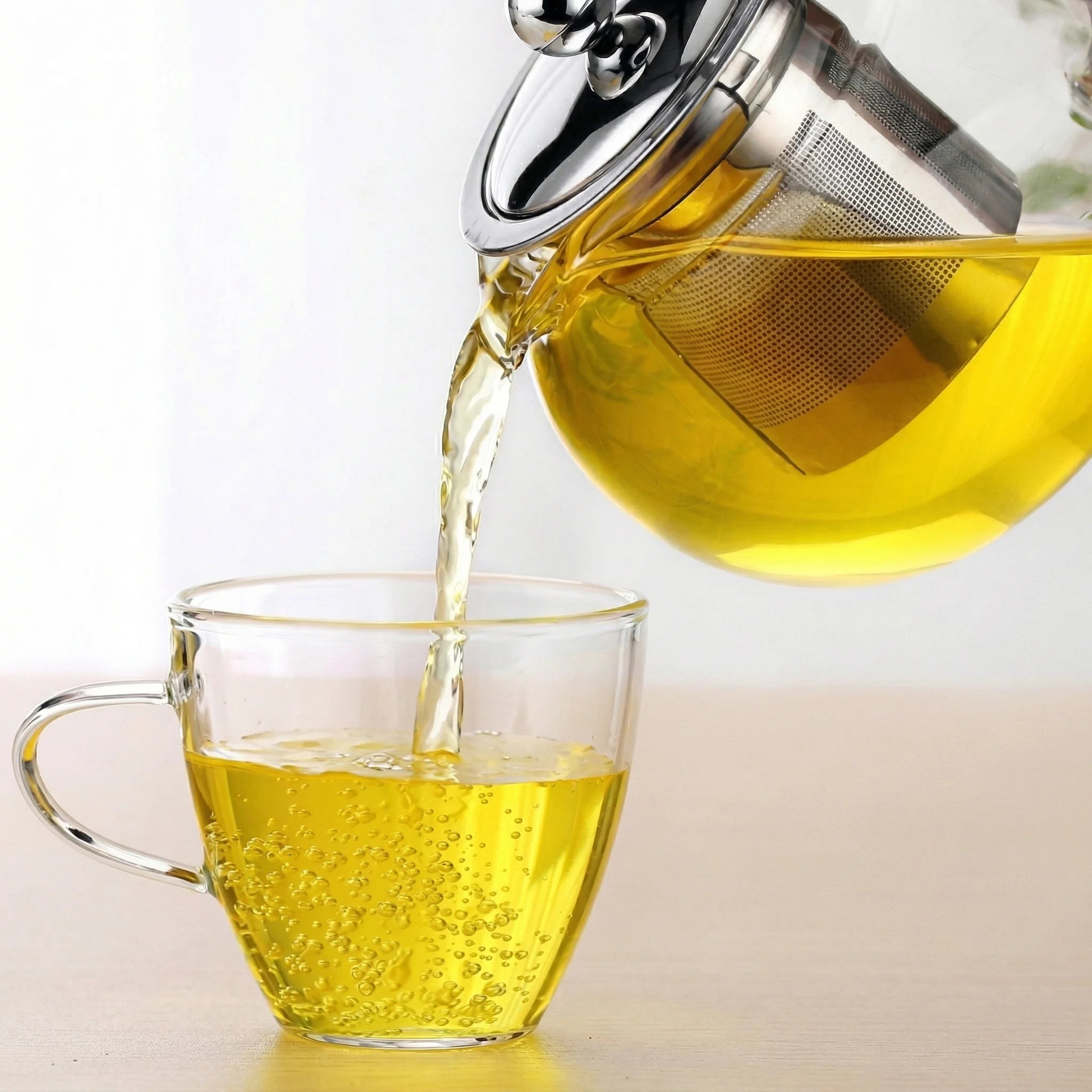 Théière en Verre Ronde versement de thé dans une tasse 