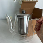 Théière en Verre avec filtre tenu par une main 