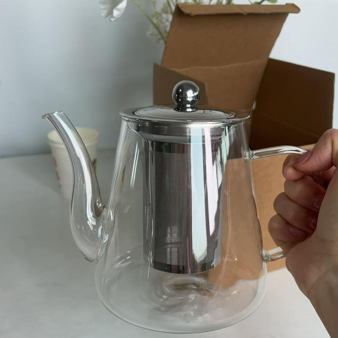 Théière en Verre avec filtre tenu par une main 