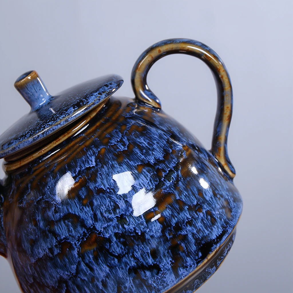 Théière en céramique bleu vue sur la poignée 