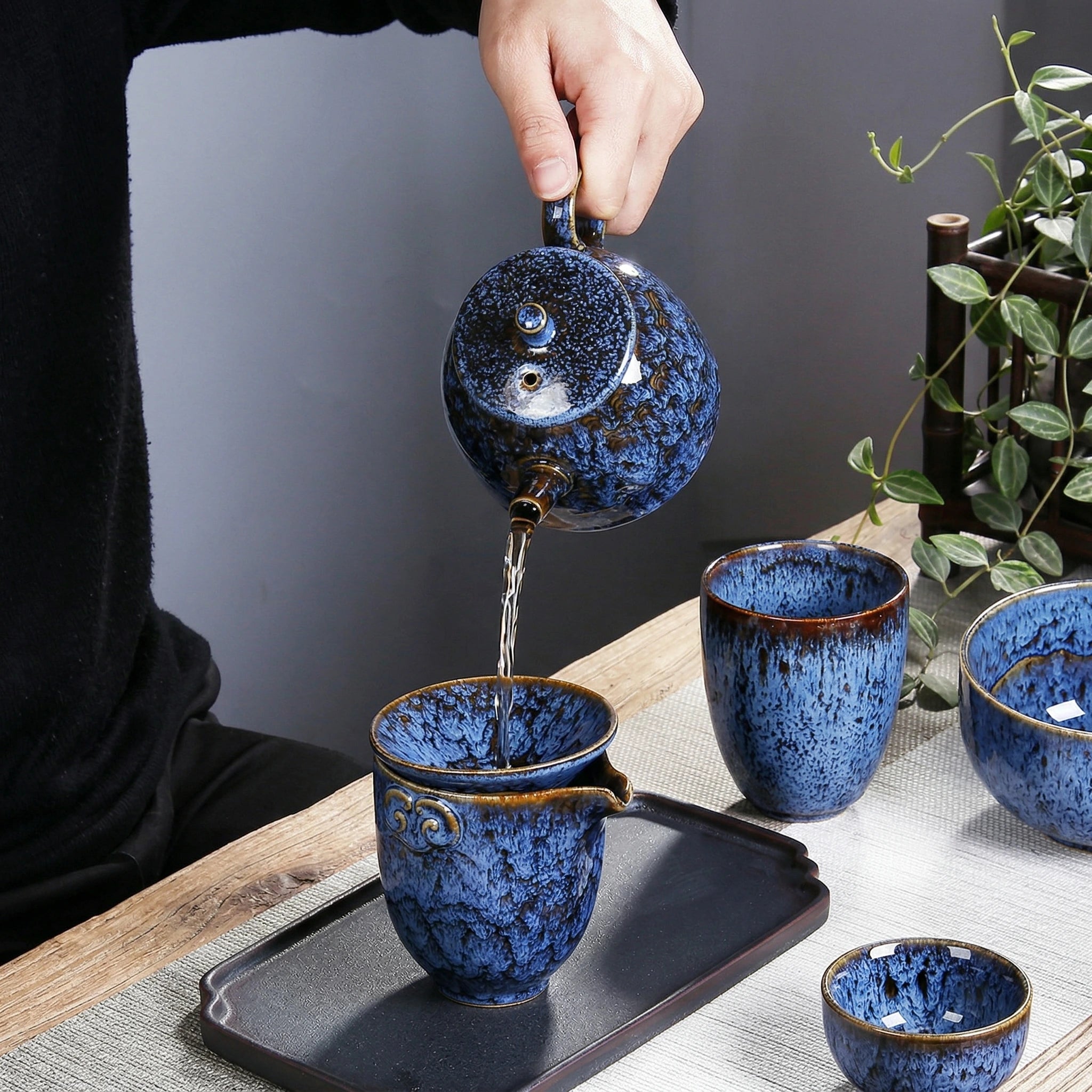 Théière en céramique bleu versant du thé 