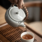 Theiere japonaise grise versant du thé dans une tasse 